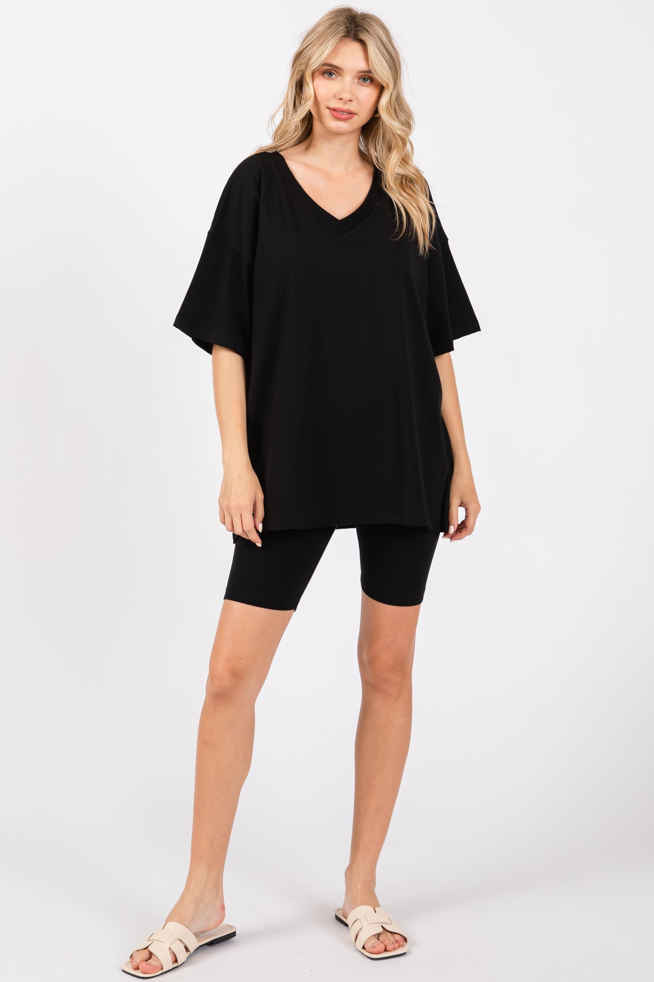 woman wearing an oversized black v-neck t-shirt with black biker shorts and sandals