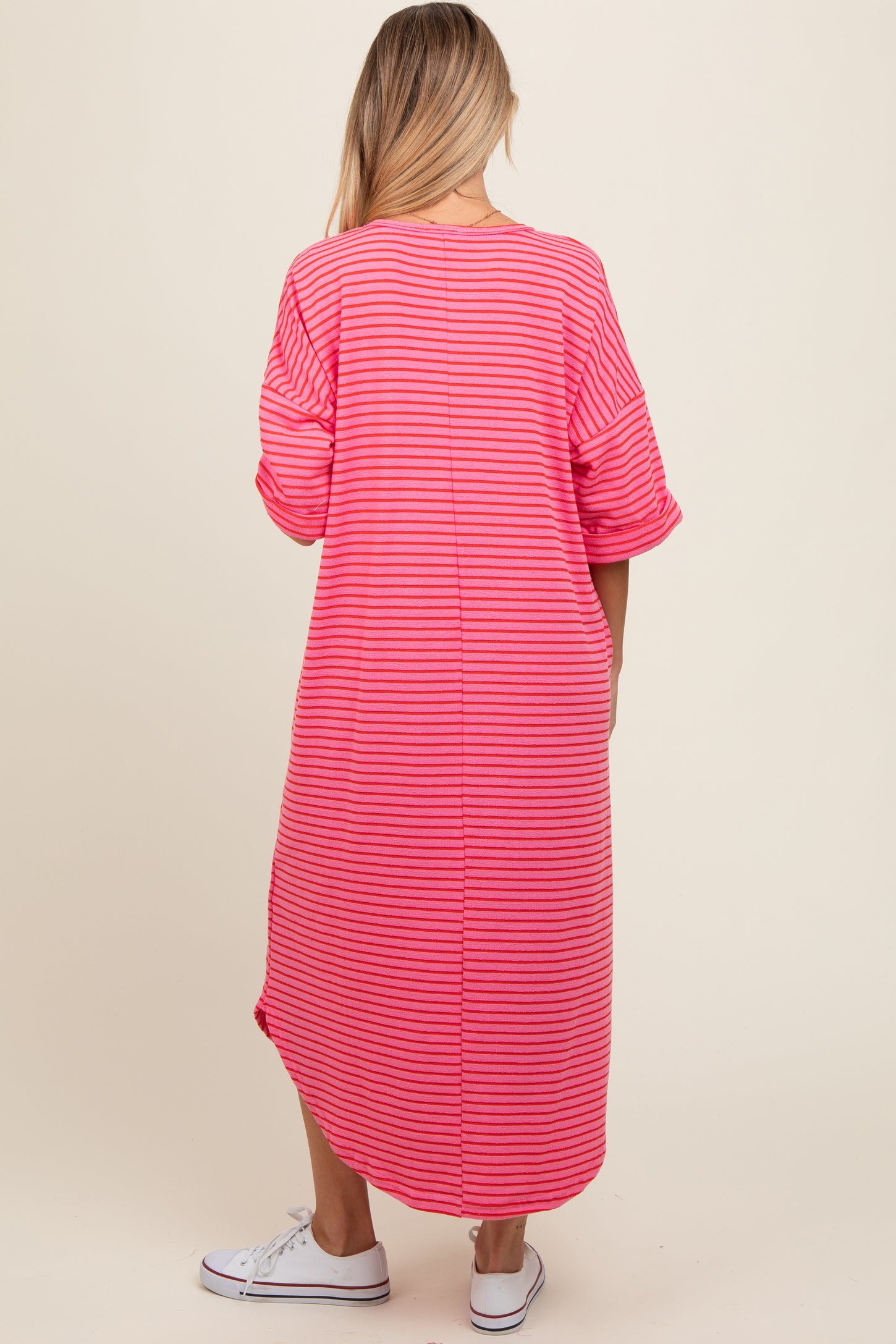 woman wearing a pink and white striped maternity maxi dress with relaxed fit and side slits, seen from the back