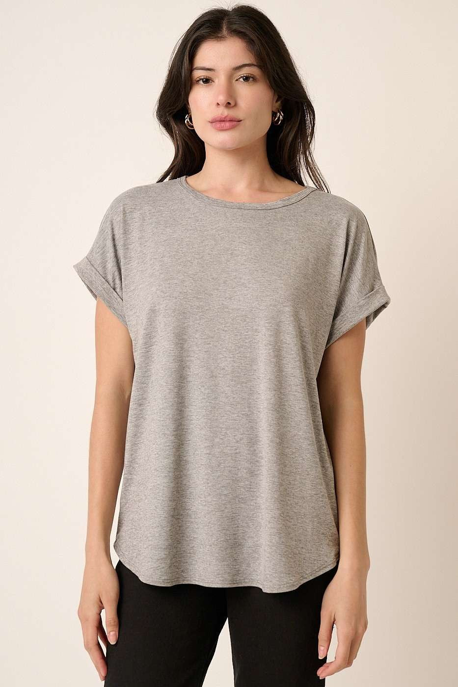 woman wearing a gray short sleeve t-shirt with rolled cuffs and a relaxed fit