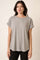 woman wearing a gray short sleeve t-shirt with rolled cuffs and a relaxed fit