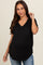 woman wearing a black v-neck maternity top with a pocket and a baby bump visible, paired with light blue jeans