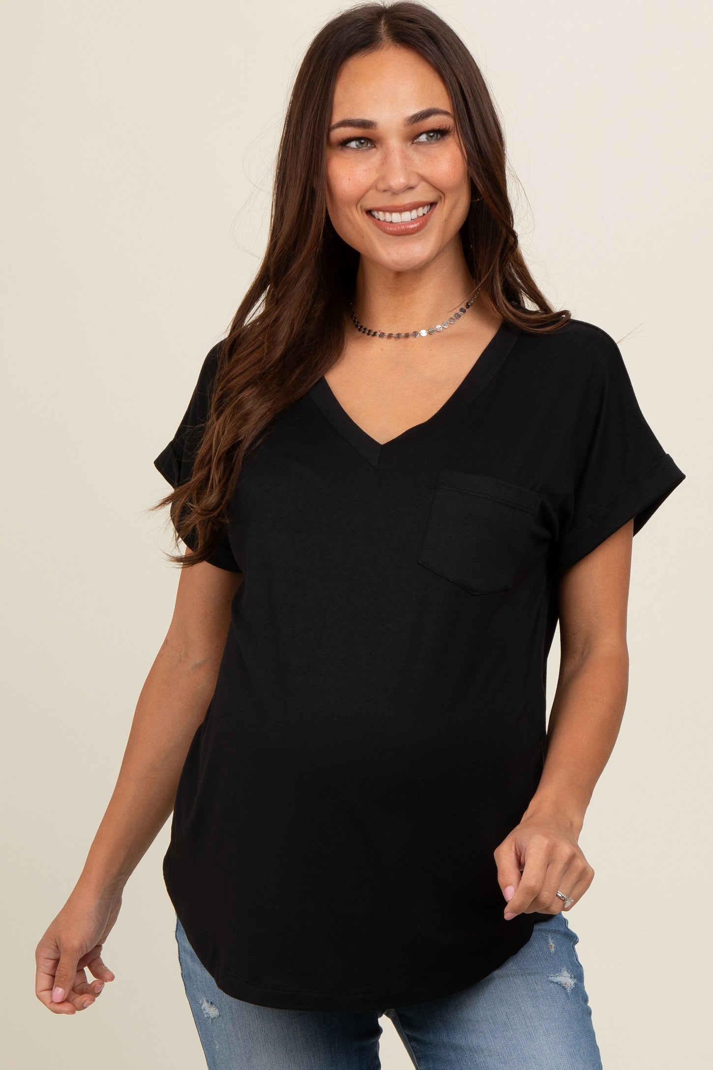 woman wearing a black short sleeve v-neck maternity top with a pocket and visible baby bump