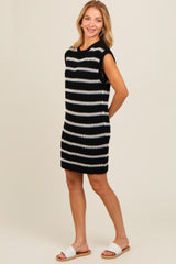 woman wearing a black and white striped sleeveless knit dress with a relaxed fit and flat sandals