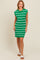 woman wearing a green and white striped knitted sleeveless dress and white sandals