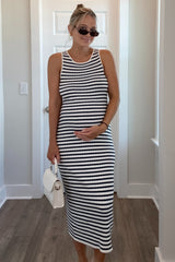 woman wearing a black and white striped maternity dress and holding her baby bump