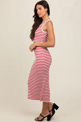 woman wearing a red and white striped midi dress with a fitted silhouette and side slit, pairing with black heeled sandals