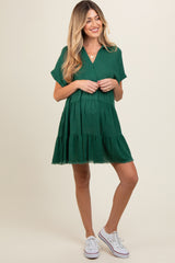woman wearing a green maternity dress with short sleeves and a tiered hem, showing her baby bump