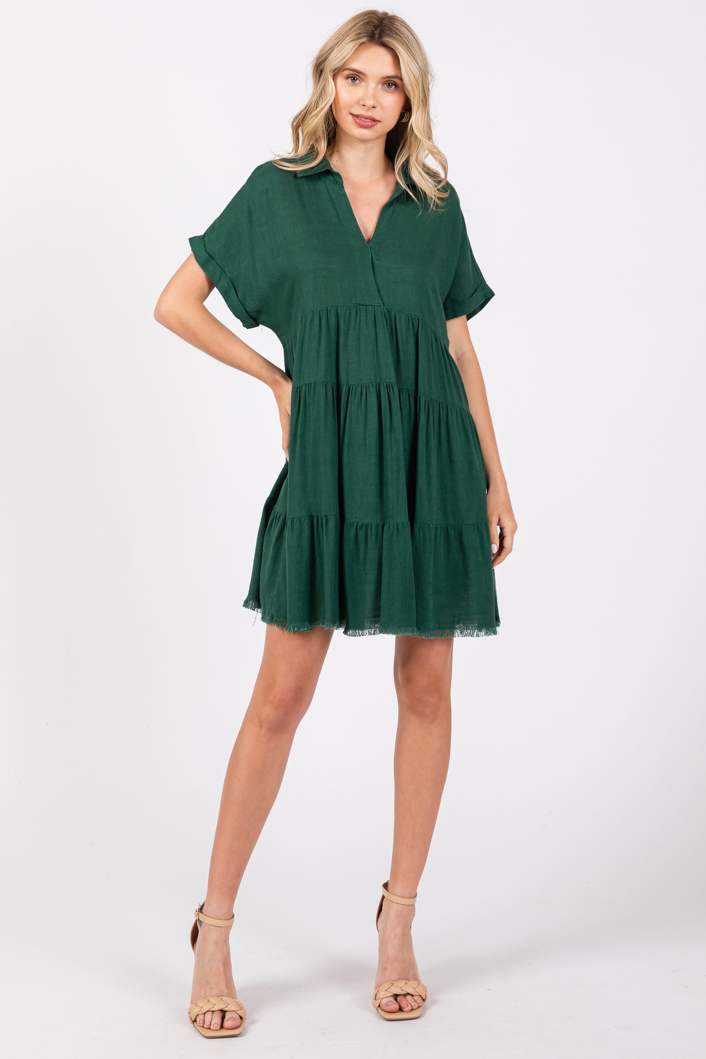 woman wearing a green tiered short sleeve dress with a v-neckline and a relaxed fit