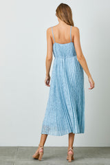 woman wearing a light blue pleated maxi dress with adjustable straps and a cinched waist, viewed from the back
