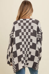 woman wearing a chunky oversized black and white checkered maternity cardigan, with a loose fit and dropped shoulders