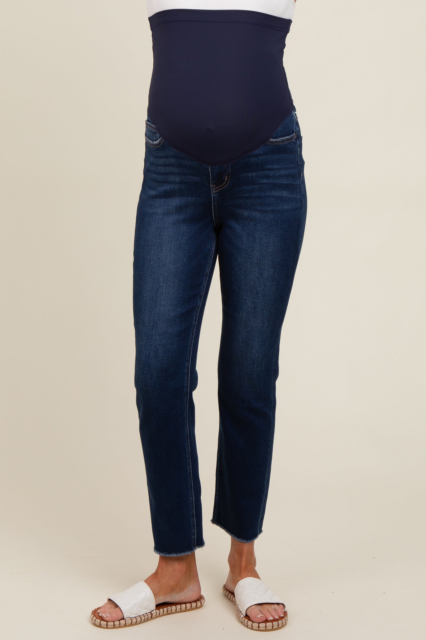 woman wearing dark blue maternity jeans with a supportive belly band and sandals