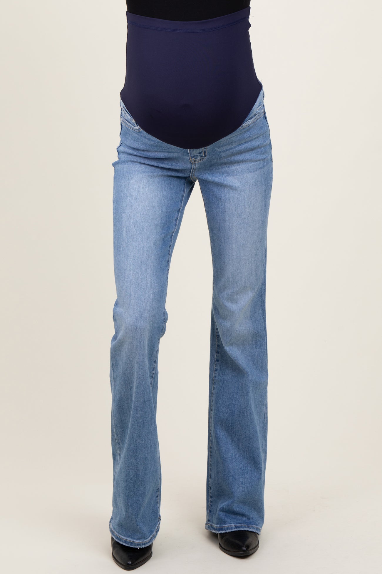 woman wearing light blue maternity flared jeans with a dark blue over-the-bump panel