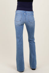 woman wearing light blue maternity flared jeans viewed from the back, showcasing pockets and a comfortable fit