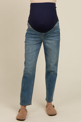 maternity wear dark blue high-waisted jeans with a wide belly band, worn with light brown sandals
