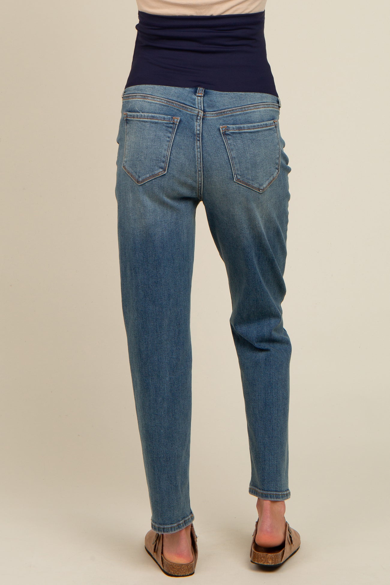maternity wear light wash skinny jeans with a dark waistband, model facing away showing the back view