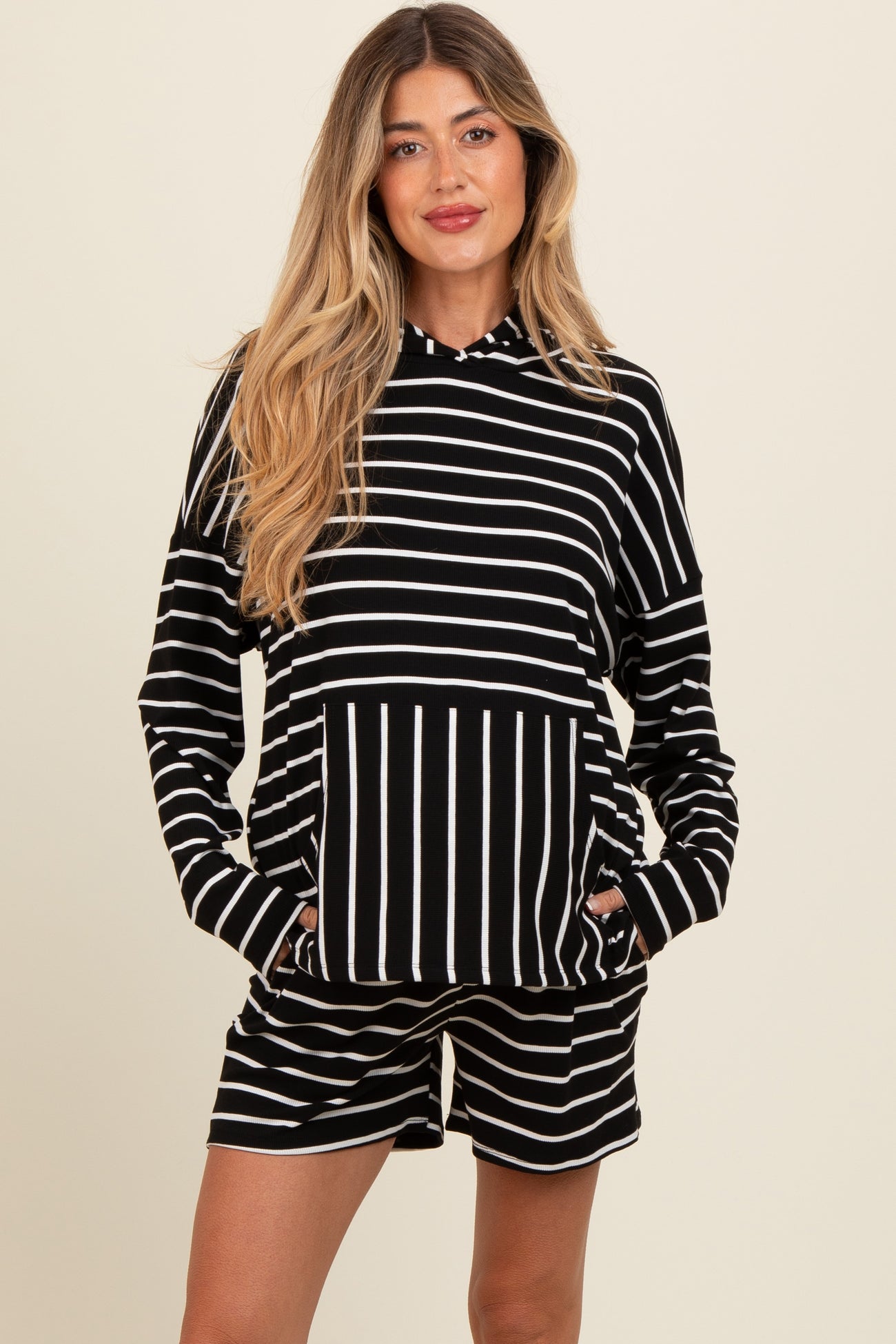 woman wearing a black and white striped maternity lounge set with a hoodie and shorts