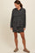 woman wearing a black and white striped hooded top with pockets and matching shorts