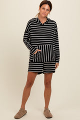woman wearing a black and white striped hoodie with a front pocket and matching shorts, styled casually