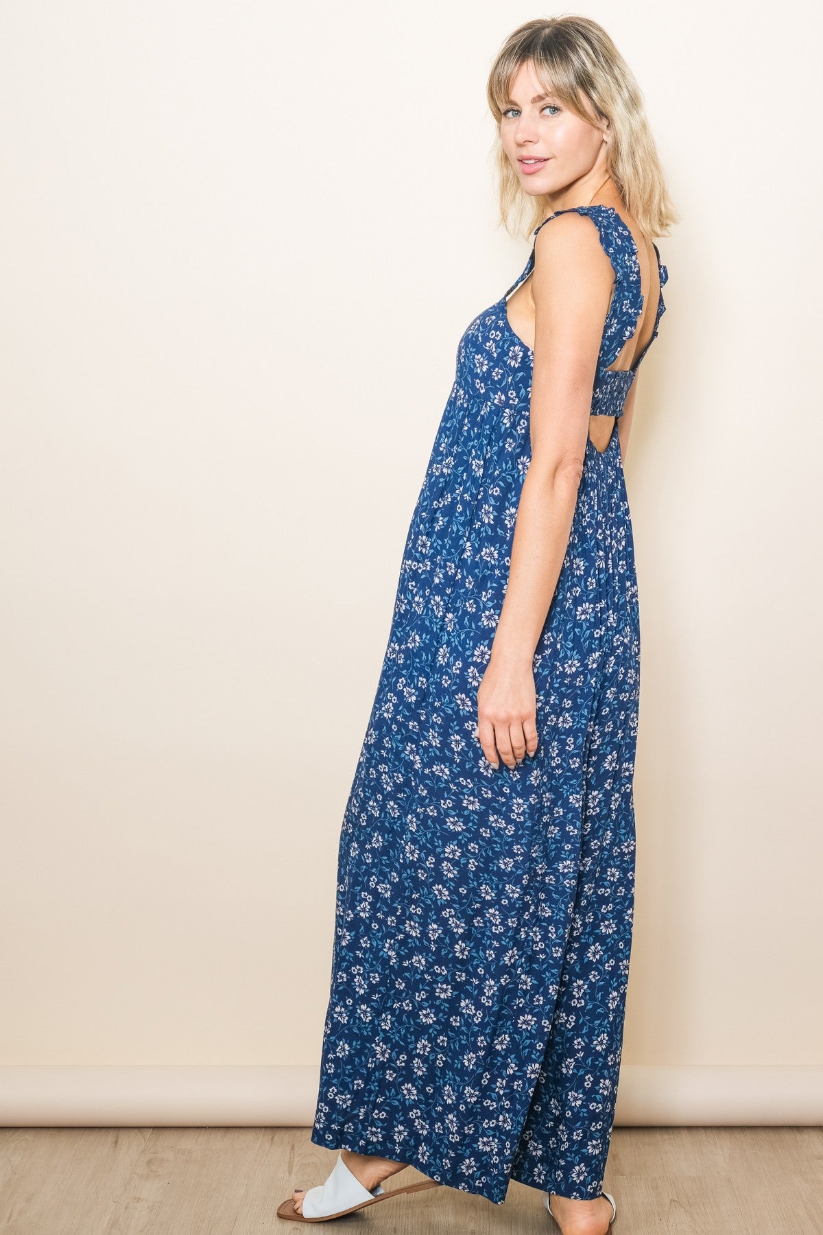 woman wearing a blue floral maxi dress with a back cutout and ruffled straps