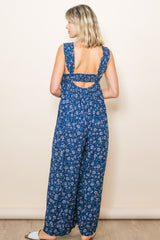 woman wearing a navy blue floral maxi dress with open back and wide straps