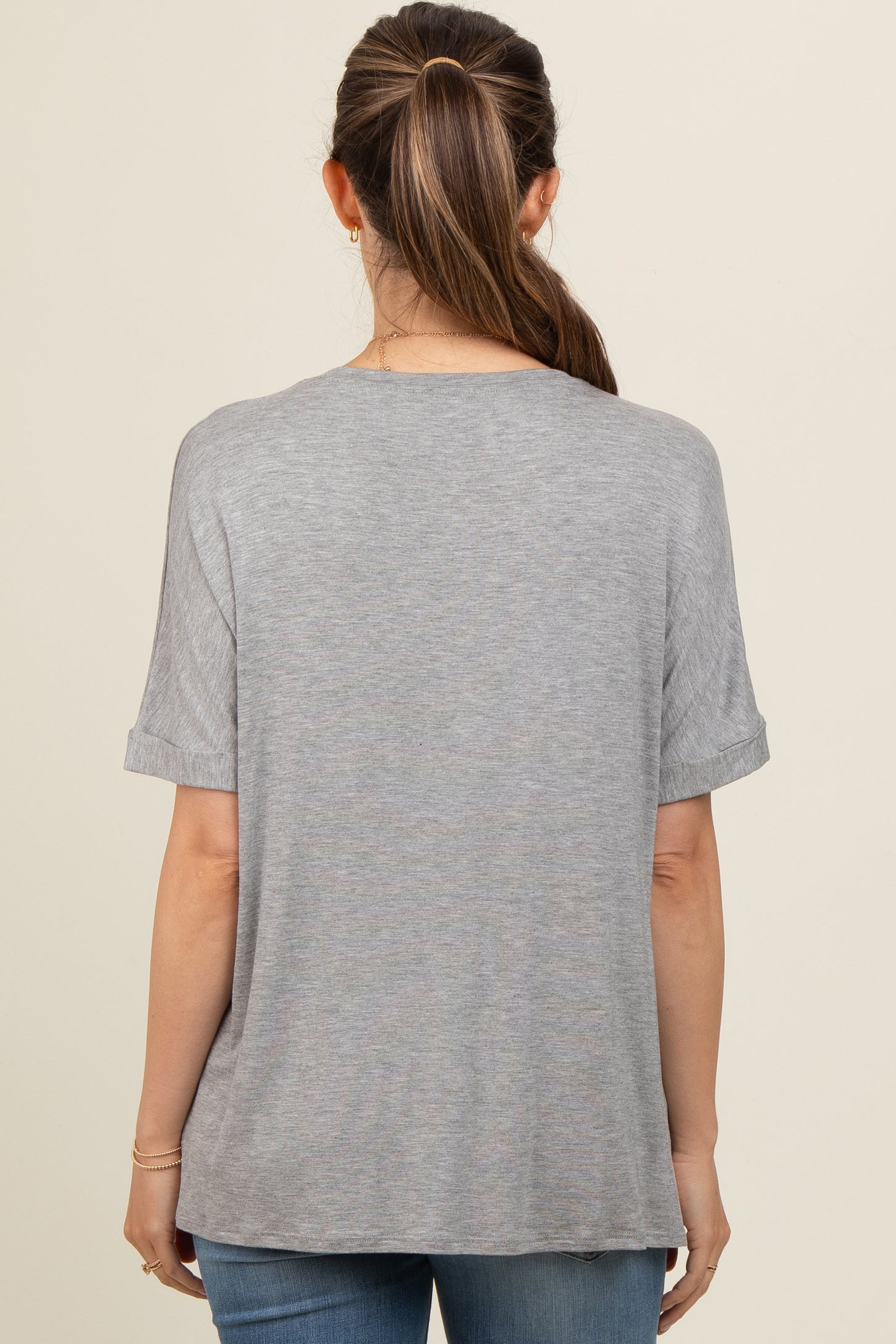 woman wearing a gray maternity t-shirt with rolled sleeves, viewed from the back