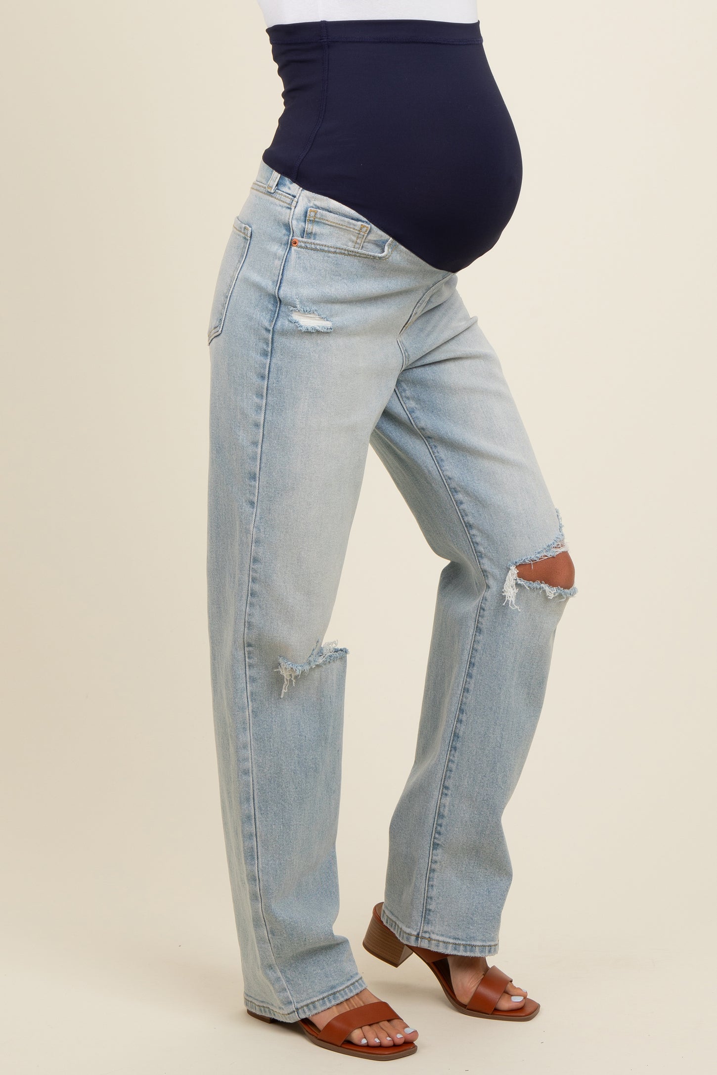 maternity wear distressed light wash jeans with a navy blue belly band and a visible baby bump