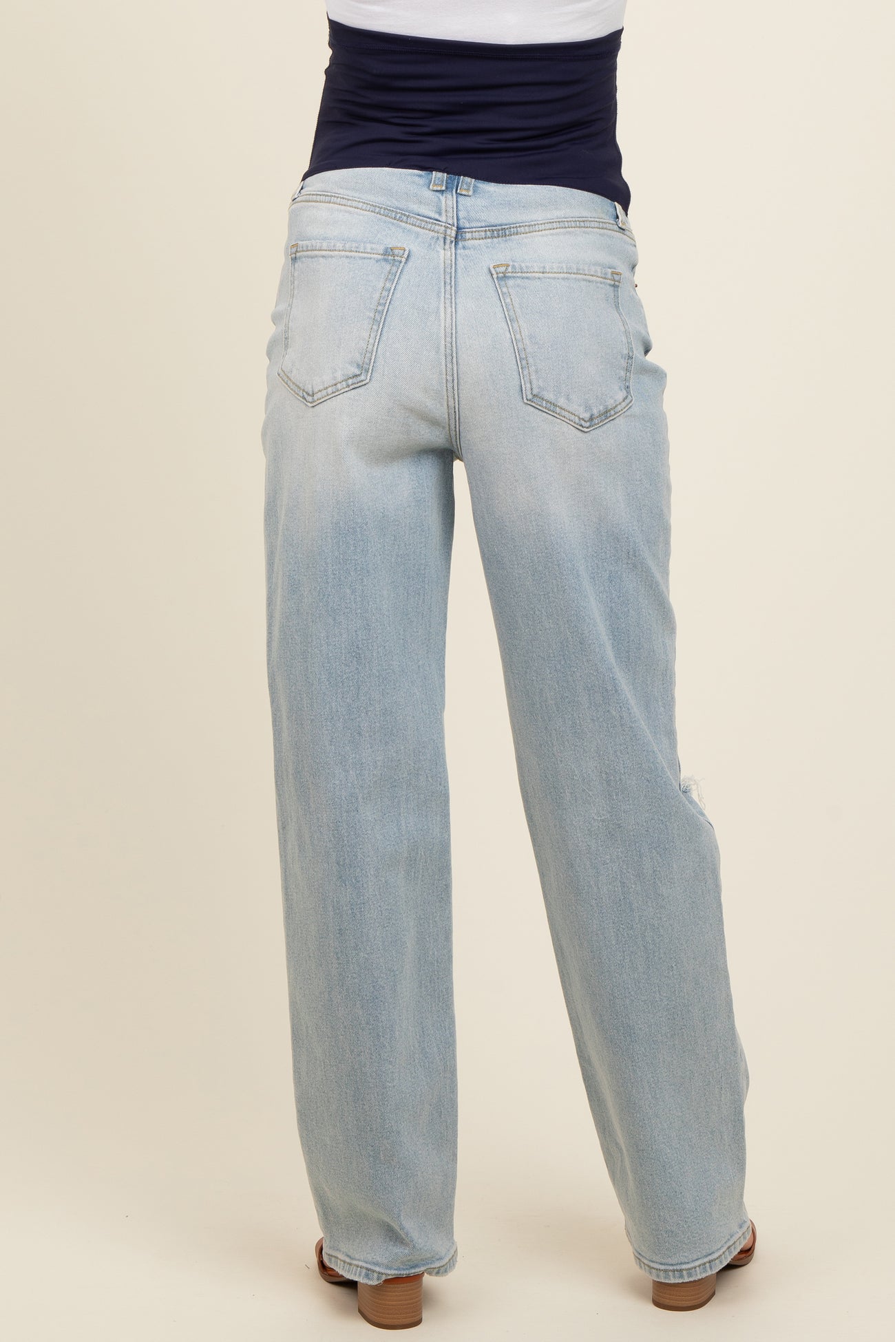 woman wearing light blue maternity jeans, viewed from the back