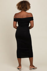 woman wearing a black off-shoulder ruched midi dress viewed from the back