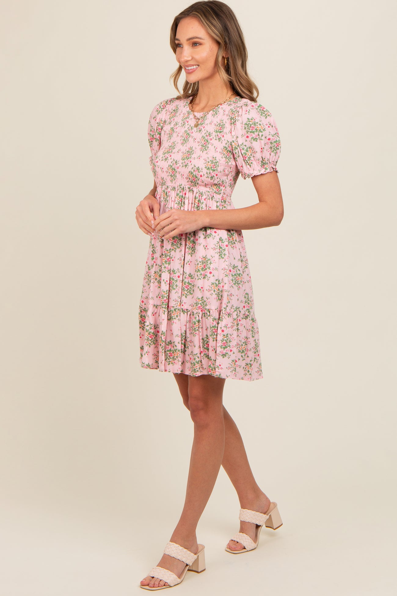woman wearing a pink floral puff sleeve dress with a tiered hem and a relaxed fit