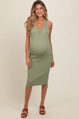 woman wearing a green ribbed maternity dress with a v-neckline and buttons, showing her baby bump