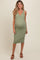 woman wearing a green ribbed maternity dress with a v-neckline and buttons, showing her baby bump