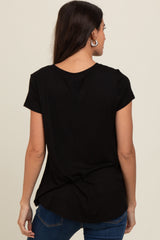 woman wearing a black short sleeve top, showing the back view with a curved hem and a relaxed fit
