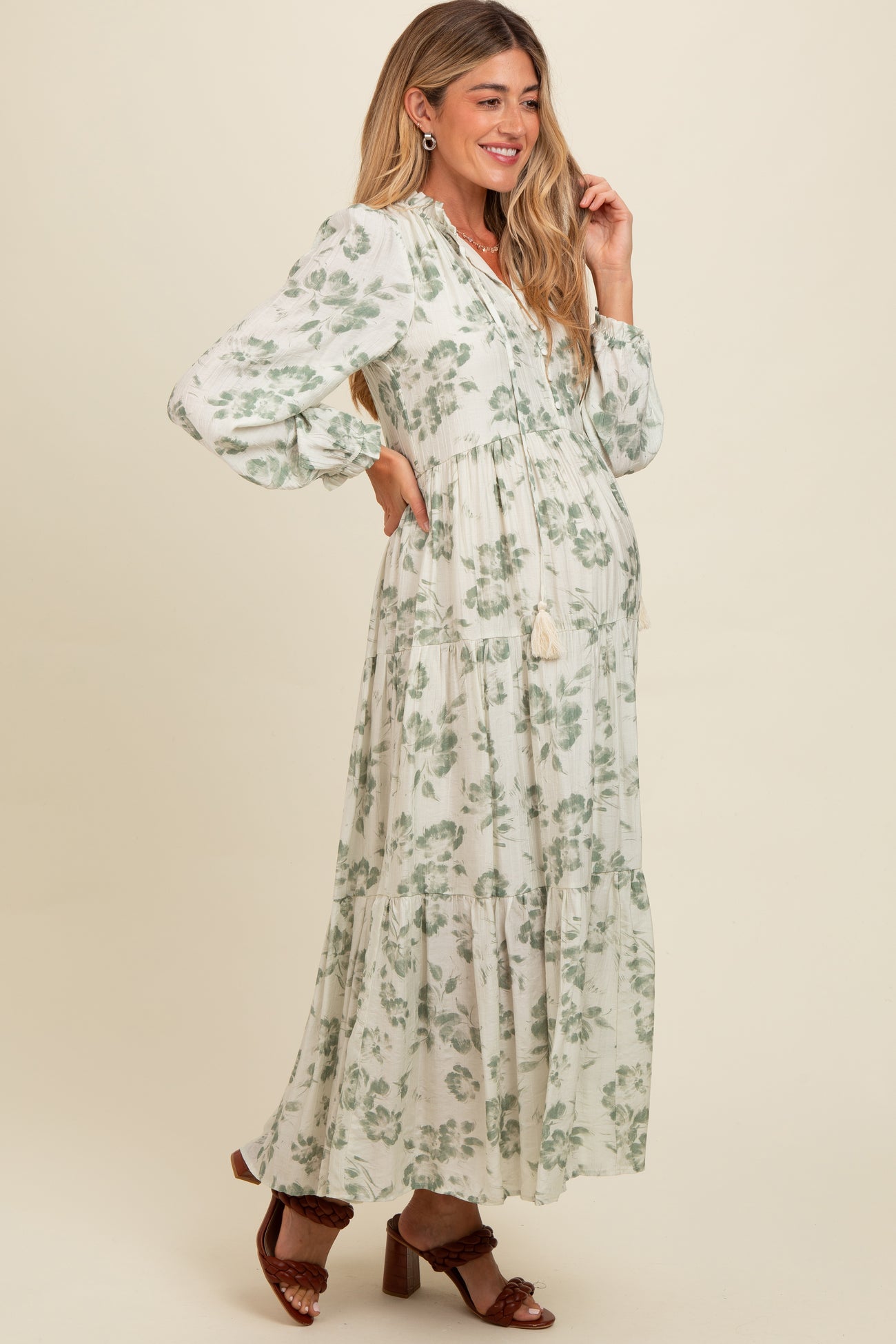 woman wearing a floral print maternity maxi dress with puff sleeves and a baby bump visible