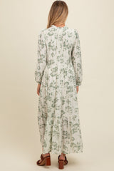 woman wearing a floral print long sleeve maternity maxi dress, showing the back view with a tiered skirt