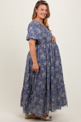 woman wearing a blue floral maternity maxi dress, showing her baby bump with a tiered ruffle hem