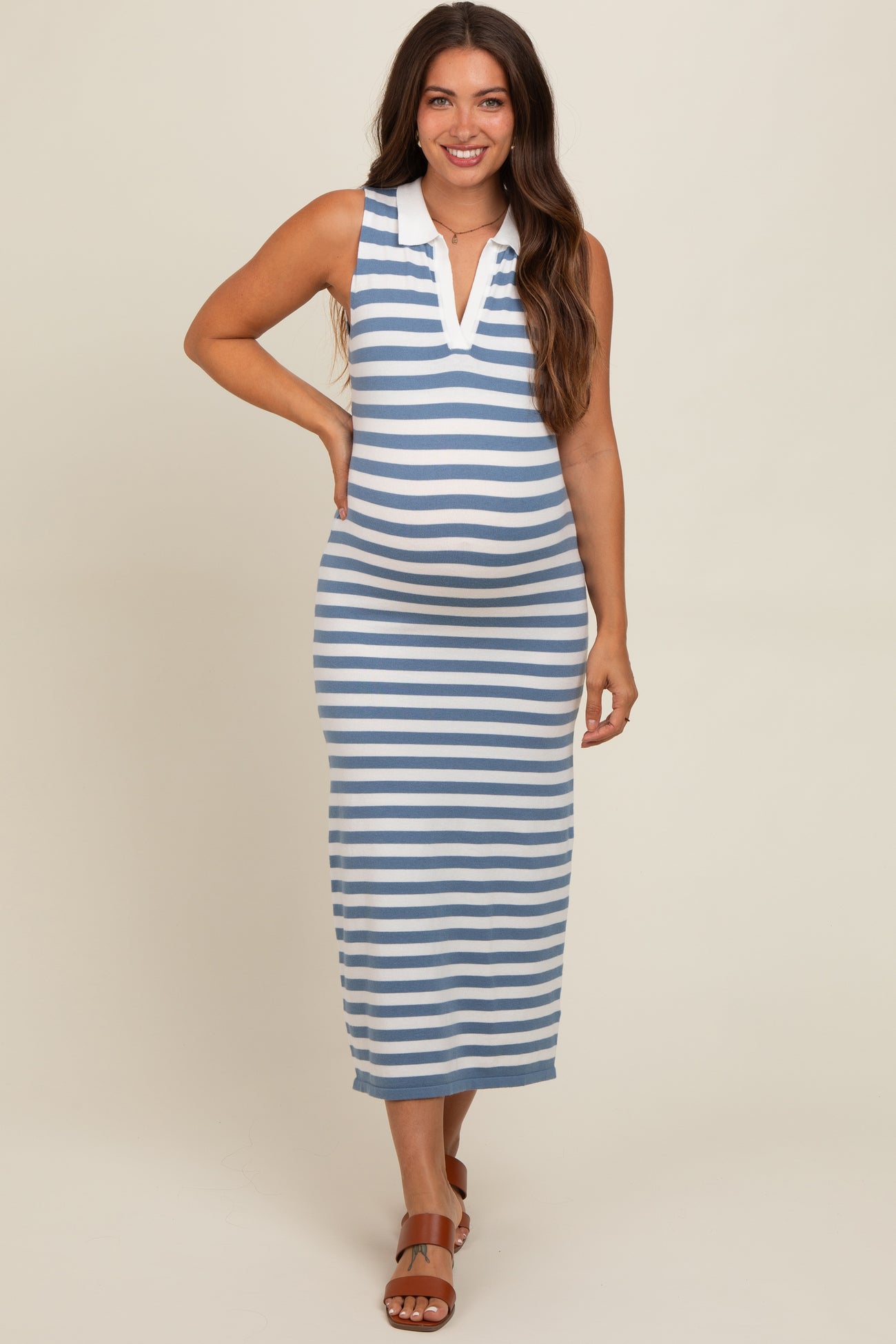 woman wearing a blue and white striped maternity maxi dress with a collared neckline and a visible baby bump
