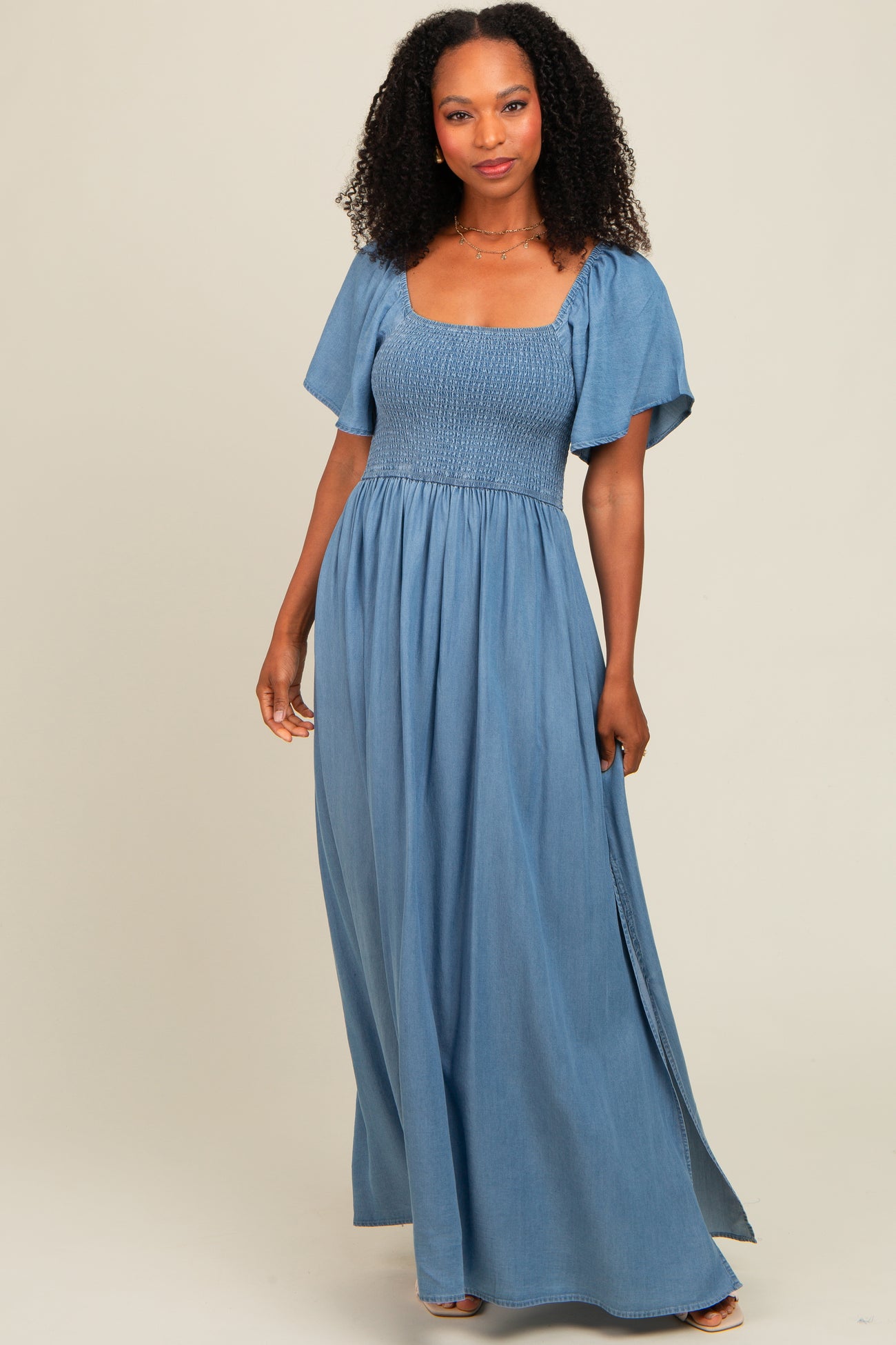 woman wearing a light blue maxi dress with a smocked bodice and short flutter sleeves