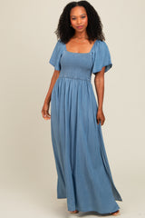 woman wearing a light blue maxi dress with a smocked bodice and short flutter sleeves