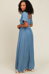 woman wearing a light blue maxi dress with short sleeves and a smocked back, styled with curls and a relaxed fit