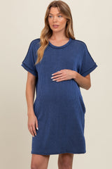 woman wearing a navy blue short sleeve maternity dress with a relaxed fit and holding her baby bump