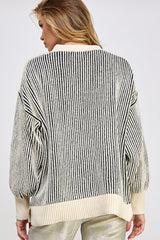 woman wearing a cream and black striped oversized sweater, showing the back view and puffed sleeves