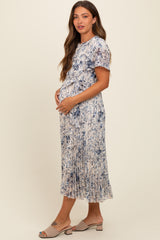 woman wearing a floral print maternity dress with a tied waist, showcasing her baby bump