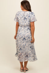 woman wearing a flowy floral print maternity dress with short sleeves and a cinched waist, standing with her back to the camera