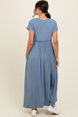 woman wearing a light blue maxi dress with short sleeves and an elastic waist, shown from the back
