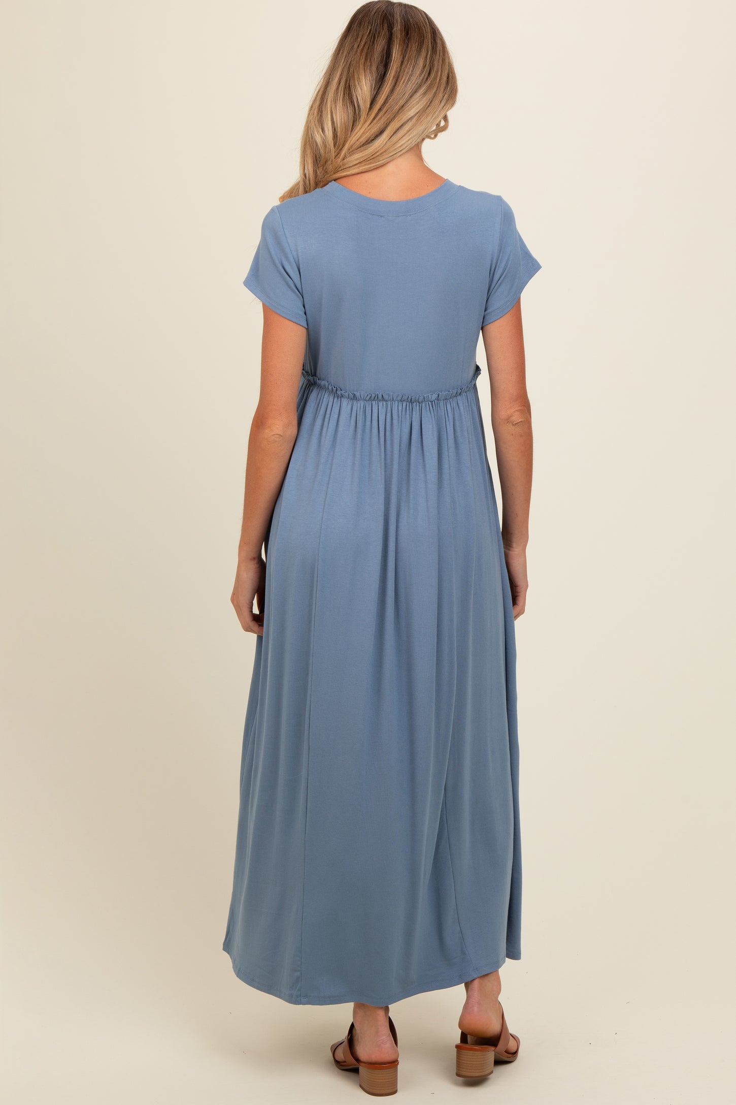 woman wearing a light blue maternity maxi dress with a gathered waist from the back