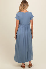 woman wearing a light blue maternity maxi dress with a gathered waist from the back