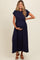 woman wearing a navy blue maxi maternity dress with a gathered waist and holding her baby bump