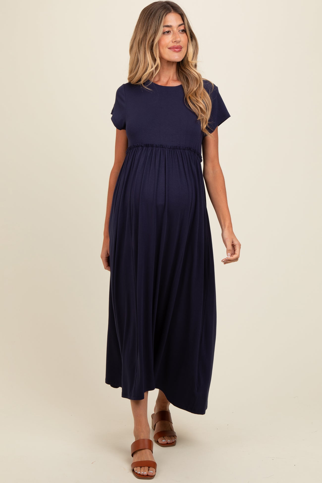 woman wearing a navy blue maternity maxi dress with short sleeves and an empire waist, baby bump visible