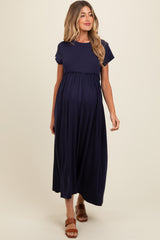 woman wearing a navy blue maternity maxi dress with short sleeves and an empire waist, baby bump visible