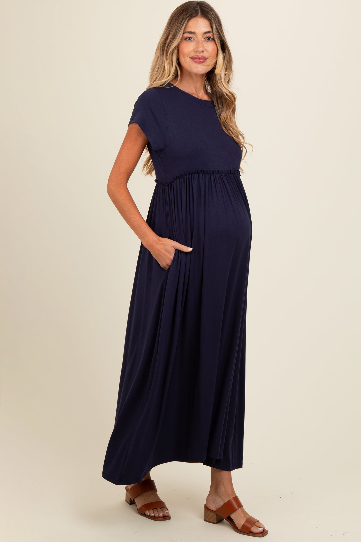 woman wearing a navy blue short sleeve maternity maxi dress with pockets and a visible baby bump